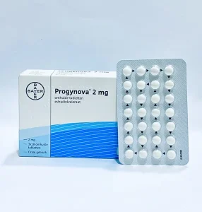 "Progynova 2mg tablet packaging showing white box with Bayer logo and blue wave design, alongside blister pack containing white round tablets"